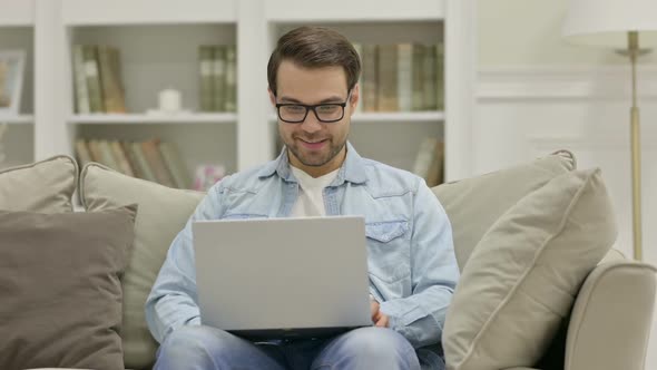 Online Video Chat on Laptop By Young Man at Home