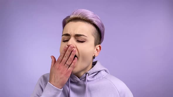 Cool Stylish Young Adult Woman Yawning Shuddering on Purple Background
