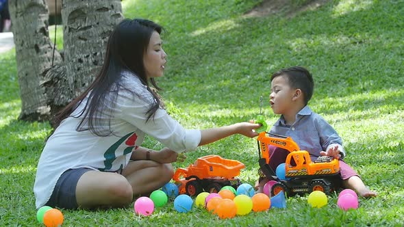 Mother with Her Son Blowing Soap Bubbles  on the Grass