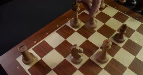 Top View of Male Hand Moving Bishop Figure Playing Chess Game
