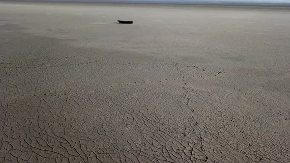 Top View of Boat at Shore of Dried Up Sea Global Warming and Drought Concept