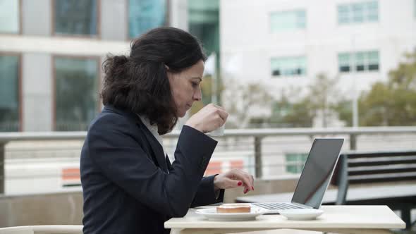 Businesswoman Working with Laptop in Cafe