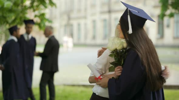 College Female Graduate Waiting for Friend to Come Giving Flowers and Hugging