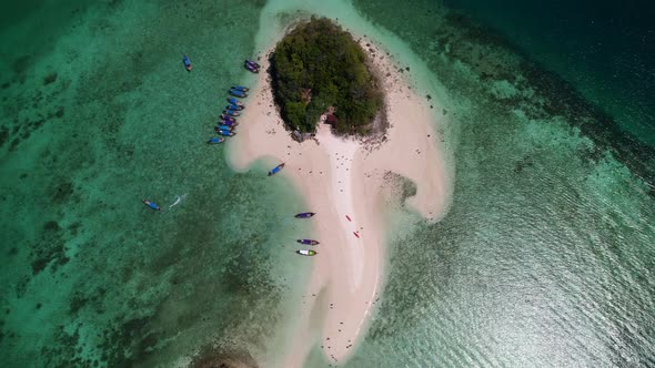 aerial top down view of Thale Waek Island in the Andaman Sea as thai longtail boats drop off tourist