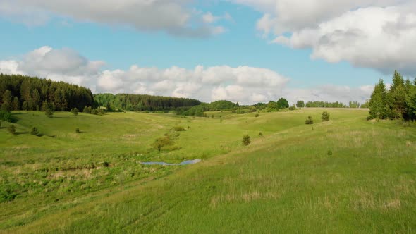 Green Open Field and Blue Sky with Some Clouds