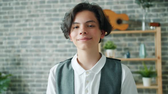 Portrait of Teenage Boy Smiling Looking at Camera Standing Alone at Home