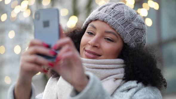 Beautiful African American Woman is Taking Selfie Using Phone Standing Outdoors Spbi