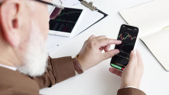 man is exploring a stock market on his phone