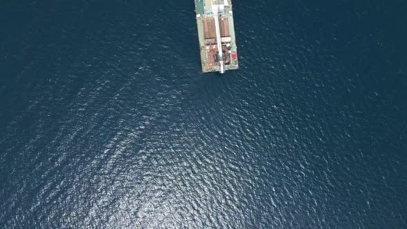 Cargo Ship with a Crane is at Sea Far From the Shore