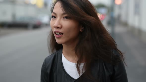 Portrait asian beautiful young woman posing looking away outdoor in the city, having fun