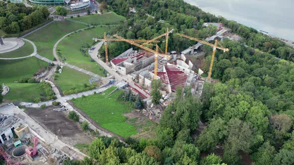Aerial View Construction of a New Building with High Tower Cranes in Green Area