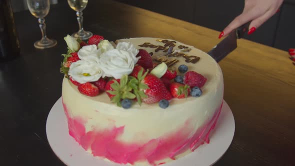 Female Hand with Knife Cutting Tasty Birthday Cake