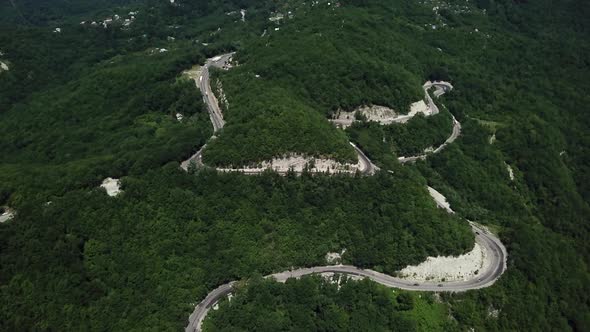 Aerial View From Above of Curve Road with a Car on the Mountain with Green Forest in Russia