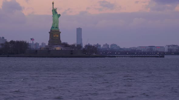 Illuminated Statue of Liberty in the Cloudy Evening. New York City. View From the Water