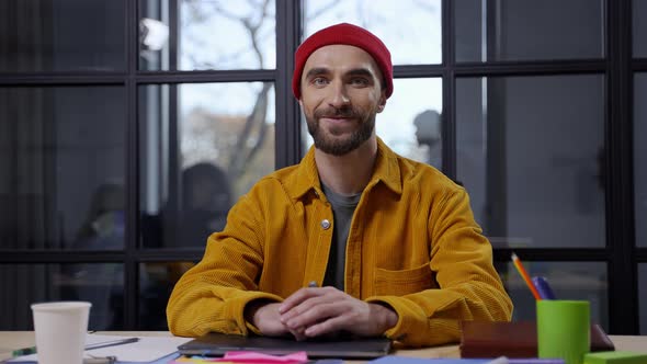 Smiling Bearded Man Posing on Camera at Desktop