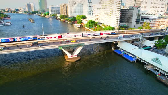 Aerial view flight over moving sky train on a bridge over the Chao Phraya River