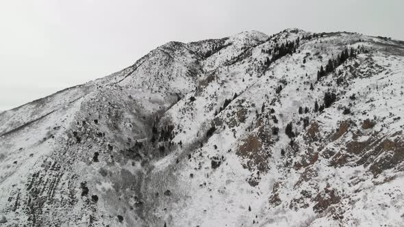 Aerial shot of snow-covered Grandeur Peak in Utah near Parley's Canyon.