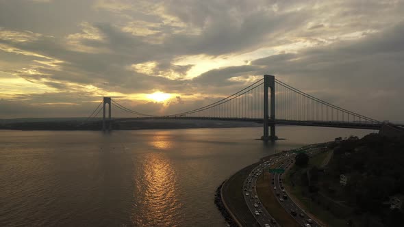 An aerial view over the Belt Parkway in Brooklyn, NY. The drone camera dollies out and tilts down sl