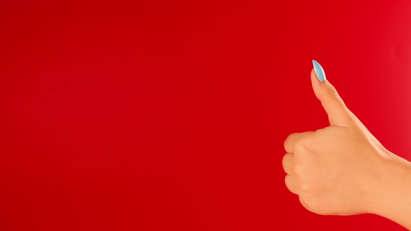 Woman's Hand Showing Thumb Up on Red Background with Space for Text