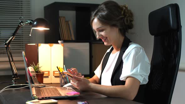 Businesswoman Sitting At Her Workplace In Office And Use Smart Phone