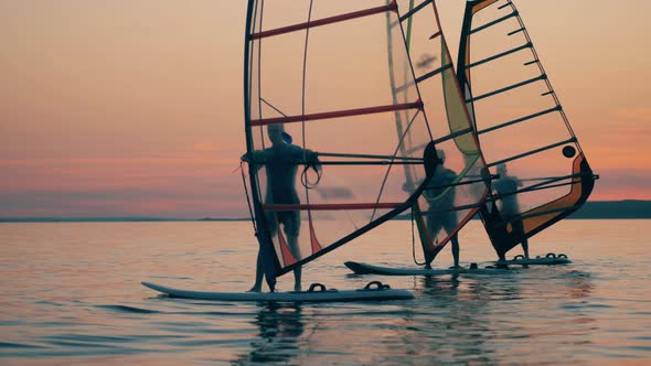 Windsurfers Are Floating Along the Lake at Sundown