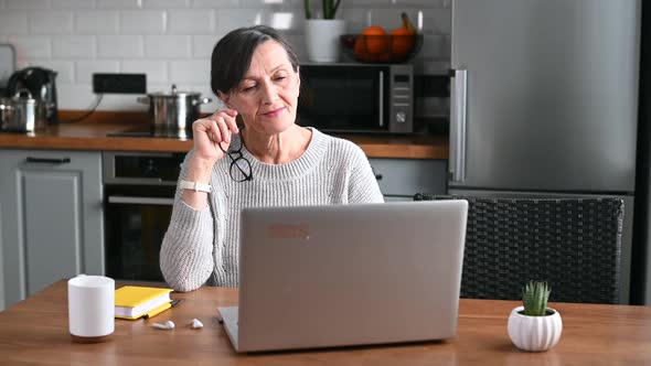 Senior Woman Using Laptop at Home Working Remotely