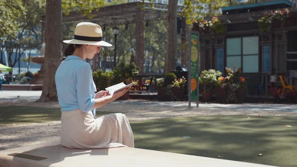 Smiling tourist with a travel book in the park