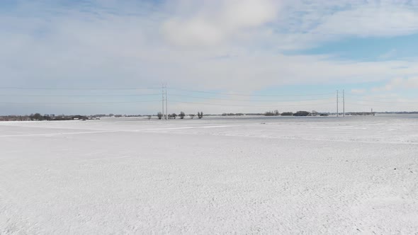 Heavy snow covering countryside fields and electricity power lines