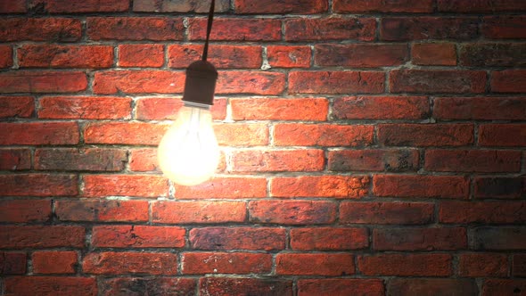 Incandescent Lamp Swinging in Dark Brickwall Room