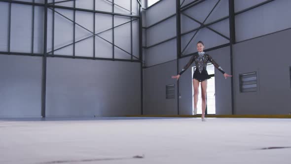 Teenage female gymnast performing at sports hall