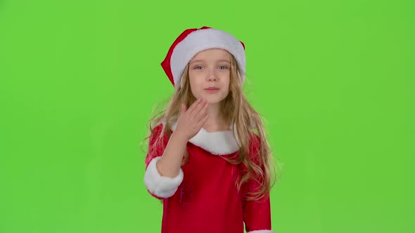 Baby Girl in Red Christmas Caps Send Air Kisses. Green Screen