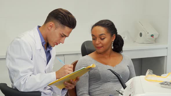 Dentist Filling Medical Papers of His Female Patient