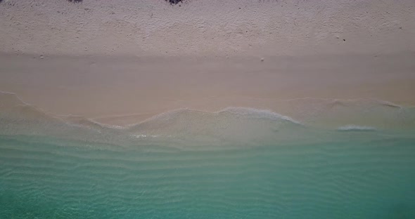 Wide angle overhead copy space shot of a white paradise beach and blue ocean background in vibrant 4