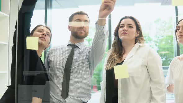 Young Corporation Employees are Discussing a Business Plan with Stickers in the Office