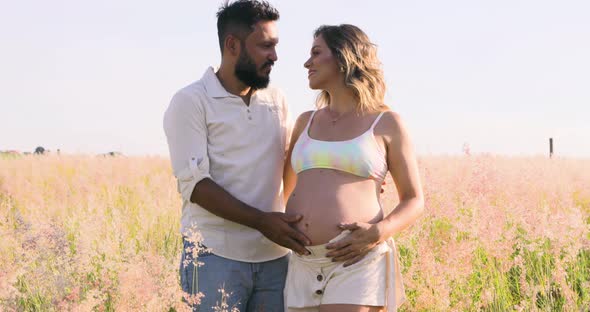 Husband holding pregnant wife's belly, baby stirred, happiness of a new life on the way.