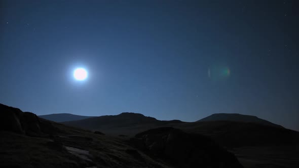 Moon Rising Above High Barren Hills at Night Time Lapse