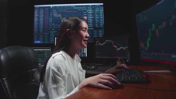 Female Stock Market Broker Working On Computer With Analysing Graphs On Multiple Computer Screens