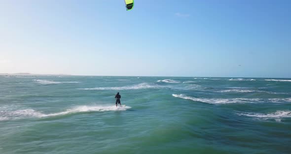 Aerial drone view of a man kiteboarding on a kite board