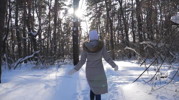 Camera Follow to Unrecognizable Girl Running on Trail Through Snowy Forest