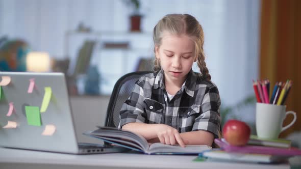 Female Student of Elementary Grades Doing Homework Reading Book at Home