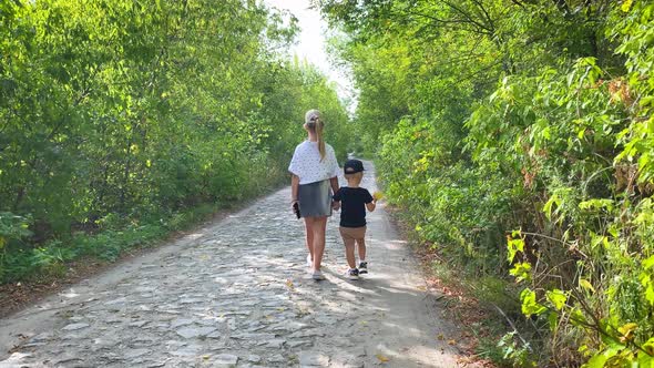 Old Sister and Little Brother Holding Hands on Walking in Forest.