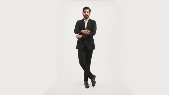 Handsome Fit Confident Bearded Cuban Man in a Black Suit Posing in a Studio Over White Background