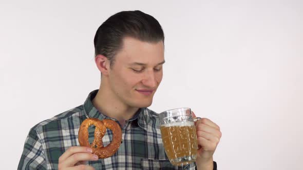 Young Attractive Man Laughing Joyfully Sipping Delicious Beer Holding a Pretzel