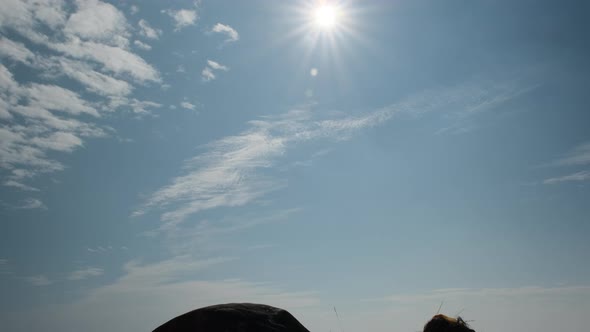 Silhouette of a successful female hiker with arms open on top of a mountain.