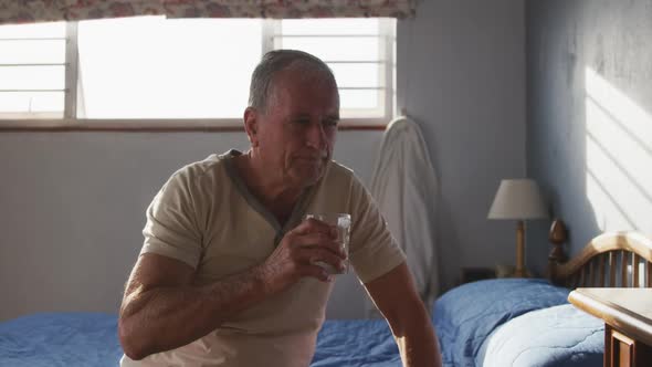 Senior man drinking water at home