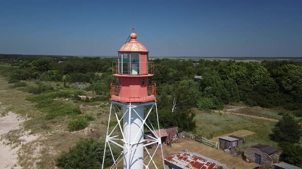 Beautiful aerial view of white painted steel lighthouse with red top located in Pape, Latvia at Balt