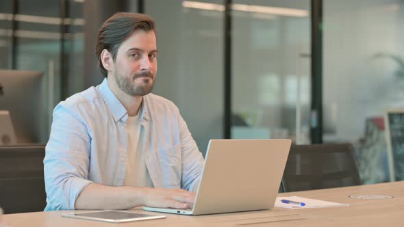 Man with Laptop Shaking Head As No Sign