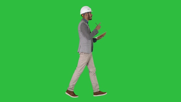 Arabic man in casual clothes and hard hat writing down