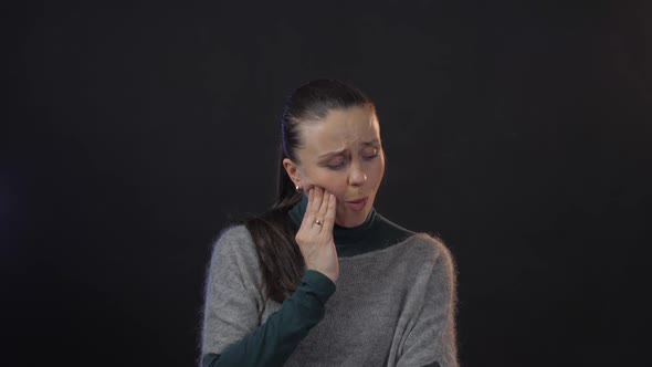 Woman Poses and Expresses Sharp Tooth Pain Touching Face