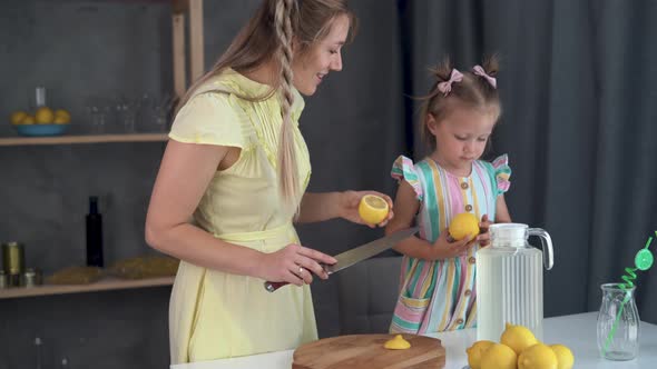 Cute Girl and Her Mother Cooking in the Kitchen Freshly Made Lemon Lemonade